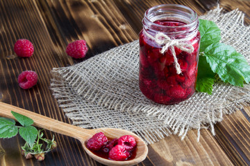 Raspberry jam on the rustic wooden background
