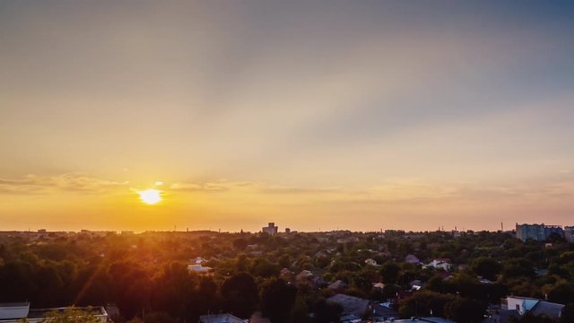 Sunset in the city. The sun sets over the horizon, the lights of the houses are lit up. Day to night timelapse