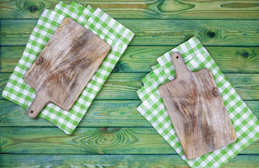 Cutting boards over green checkered tablecloths on the table, top view
