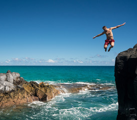 Fit young man jumps into ocean at Lumahai beach Kauai