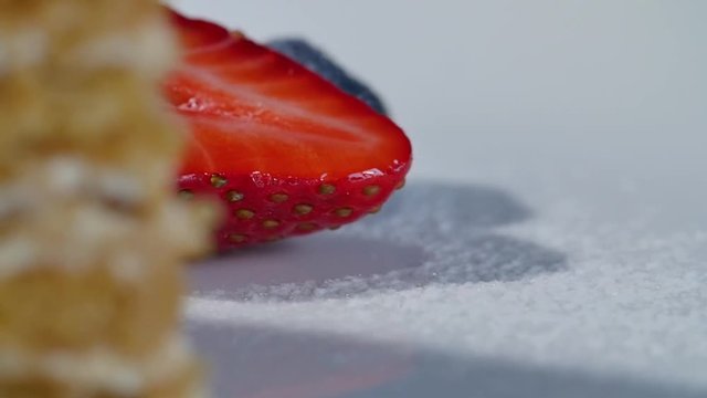 strawberry and blueberries on white plate with cake. Strawberries and Blueberries in white bowls.