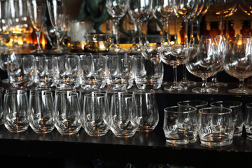 Whiskey glasses on bar counter with blur bottles background