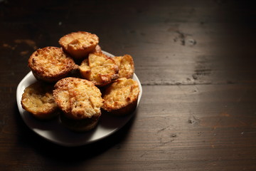Plate with beautiful muffins on a dark background.
