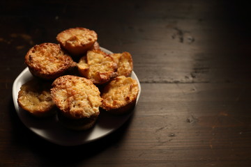 Plate with beautiful muffins on a dark background.