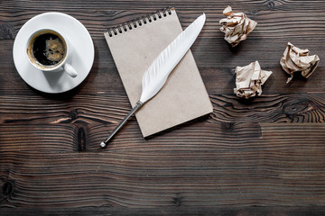 Writer concept. Feather pen, vintage notebook and crumpled paper on wooden table background top view copyspace