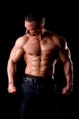 Fototapeta premium fit muscular man posing isolated on a dark background