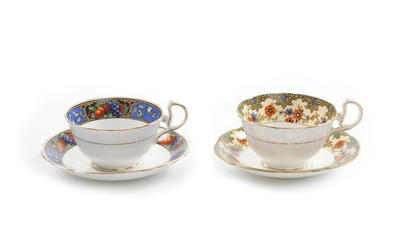 Two beautiful vintage tea cups with saucers isolated on a white background.