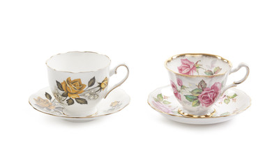 Two beautiful vintage tea cups with saucers isolated on a white background.