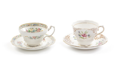 Two beautiful vintage tea cups with saucers isolated on a white background.