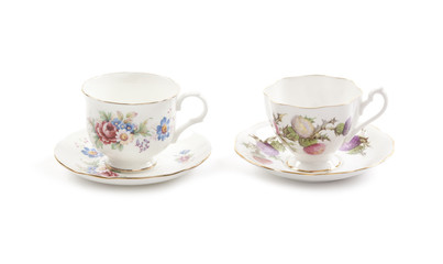 Two beautiful vintage tea cups with saucers isolated on a white background.