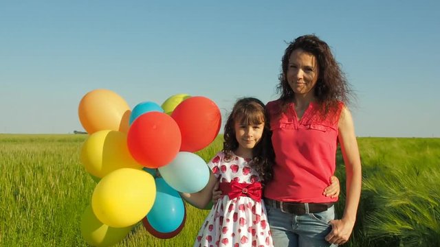 Family with balloons. Mom and daughter in nature with balloons.
