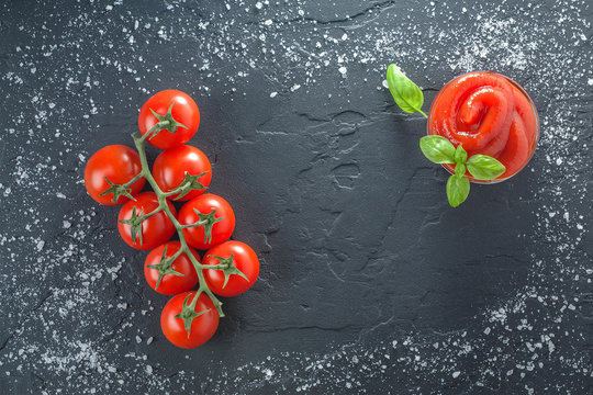 tomatoes basil ketchup on black stone with salt