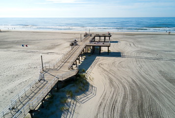 Wildwood Crest beach and wooden dock from above with the ocean view and tourists relaxing
