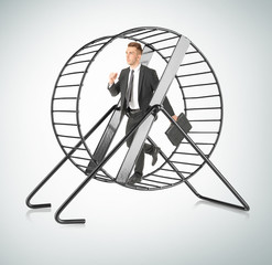 Young man running in wheel on light background. Business rat race concept