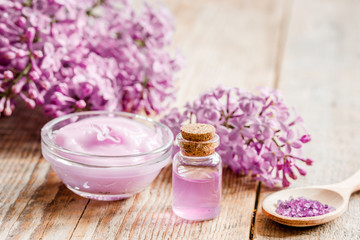 lilac natural cosmetic set for spa with salt wooden table background
