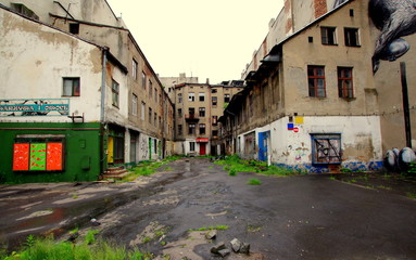 Opustoszałe Łódzkie podwórze, ze zrujnowanymi blokami i zniszczonymi witrynami