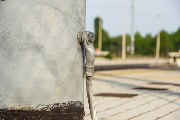 Structural detail of a lighting post steel base plate. Safety ground wire attached.