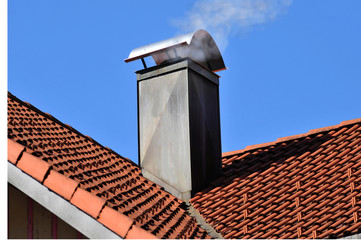 Schornstein mit Kupfer-Verkleidung auf einem Ziegeldach