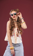 Beautiful stylish woman with sunglasses on color background