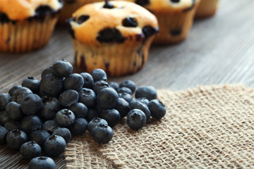 muffin with blueberries on a wooden table. fresh berries and sweet pastries on the board.