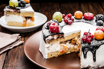 chocolate berry cake on plate over brown wooden background