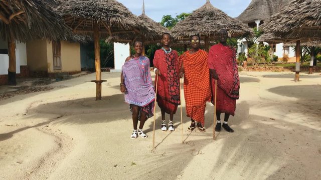 The Masai tribe dances their national African dance on the Indian Ocean beach at sunset and bids farewell to the sun. Tanzania. Zanzibar. 4K.