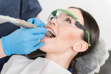 Fototapeta premium Dentist curing mouth of calm client