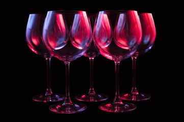 Nightclub wine glasses lit by red, blue, lilac party lights, nightlife, five object in row isolated...
