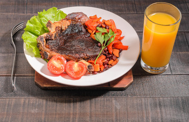 Fried beef steak with vegetables and beans on a plate