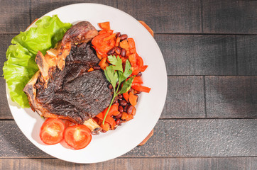 Fried beef steak with vegetables and beans on a plate
