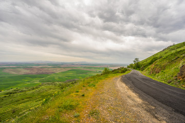 The road among green hills. Beautiful clouds over Steptoe Butte state park, Washington, USA