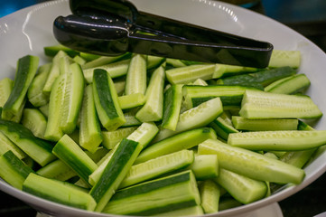 Buffet restaurant. Sliced salted cucumbers lie on the plates.