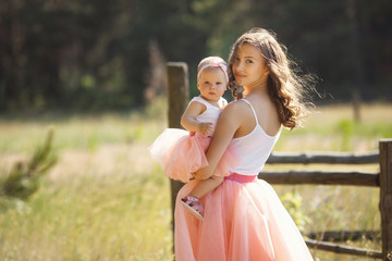 Young pretty mother with her little baby outdoors. Beautiful woman with her daughter on the nature. infant child with her parent