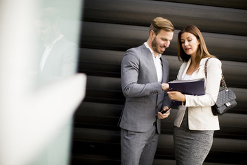 Young business people talking and viewing documents outdoor