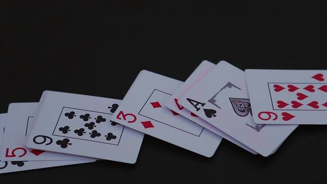 Poker cards sliding from side on the black table