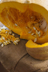Pieces of cut pumpkin together with pumpkin seeds.