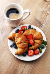 Delicious breakfast with fresh croissants, coffee and ripe berri