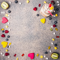 various berries, marmalade and marshmallow lined frame on granite background with fresh fruit smoothies, valentines day, top view space for text