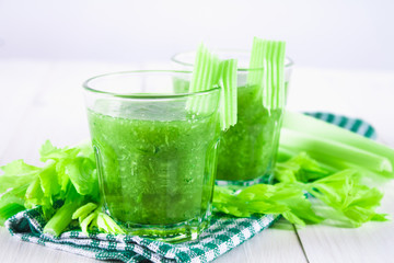 Vegetable cocktail made from celery leaves, healthy lifestyle on a white wooden background.