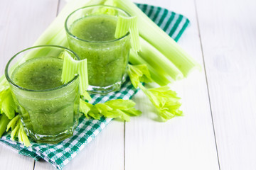 Vegetable cocktail made from celery leaves, healthy lifestyle on a white wooden background.