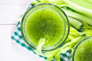 Vegetable cocktail made from celery leaves, healthy lifestyle on a white wooden background.