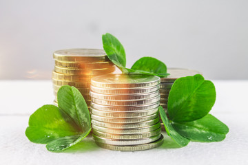 Stacks of Russian coins with clover leaves on a gray background with droplets of water. St.Patrick 's Day.