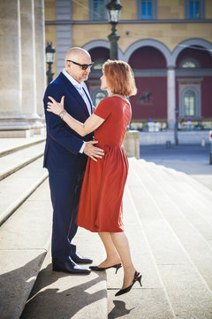 Senior couple embraces on staircase outdoors, Munich, Bavaria, Germany