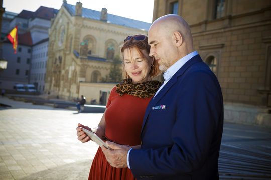 Senior couple looking at city map, Munich, Bavaria, Germany