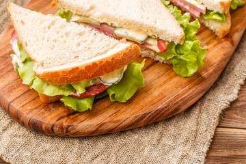 Fresh sandwiches on wooden board