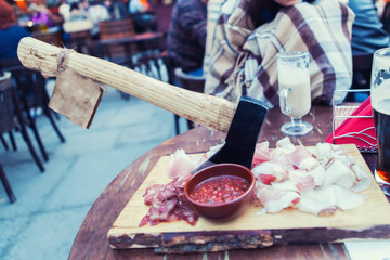 The board with homemade beef jerky - dried spiced meat, big glass of beer and bottle opener on back. Stone background
