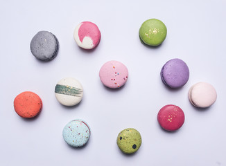 Small multicolored appetizing cake maccarone lined  on white background, place for text, top view