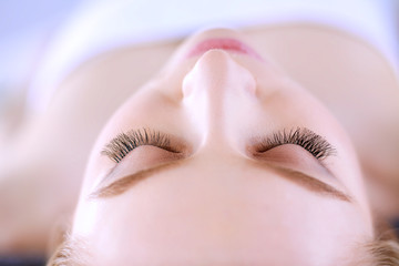 Naklejka premium Young woman lying on a massage table,relaxing with eyes closed. Woman. Spa salon