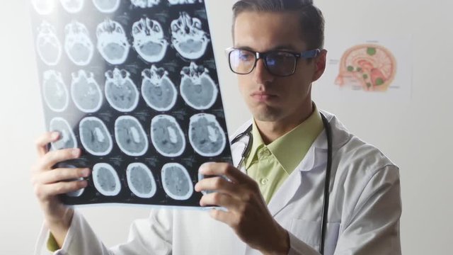 A neurosurgeon doctor looks at a Magnetic resonance imaging MRI snapshot of the brain