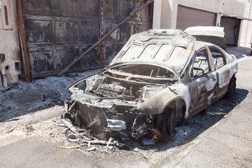 Burned out passenger car after an electrical fire in residental area